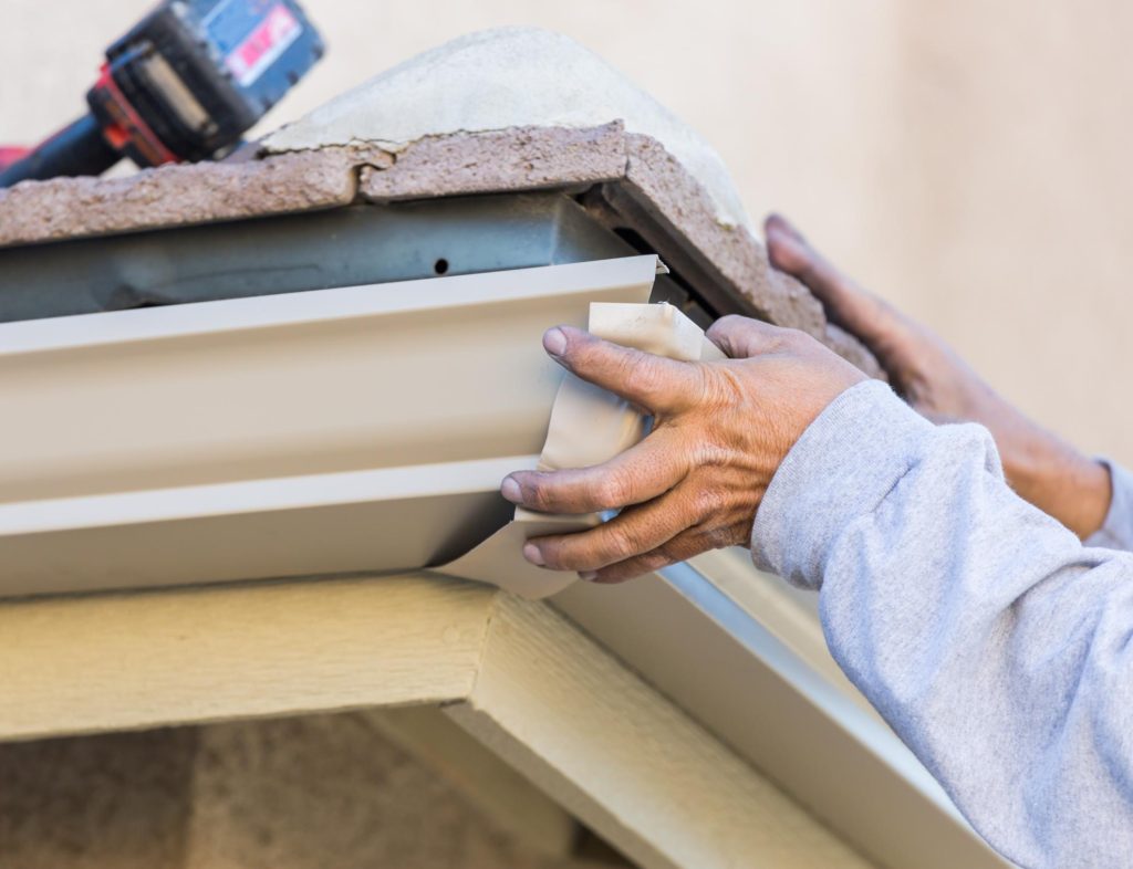 someone installing roof rain gutter