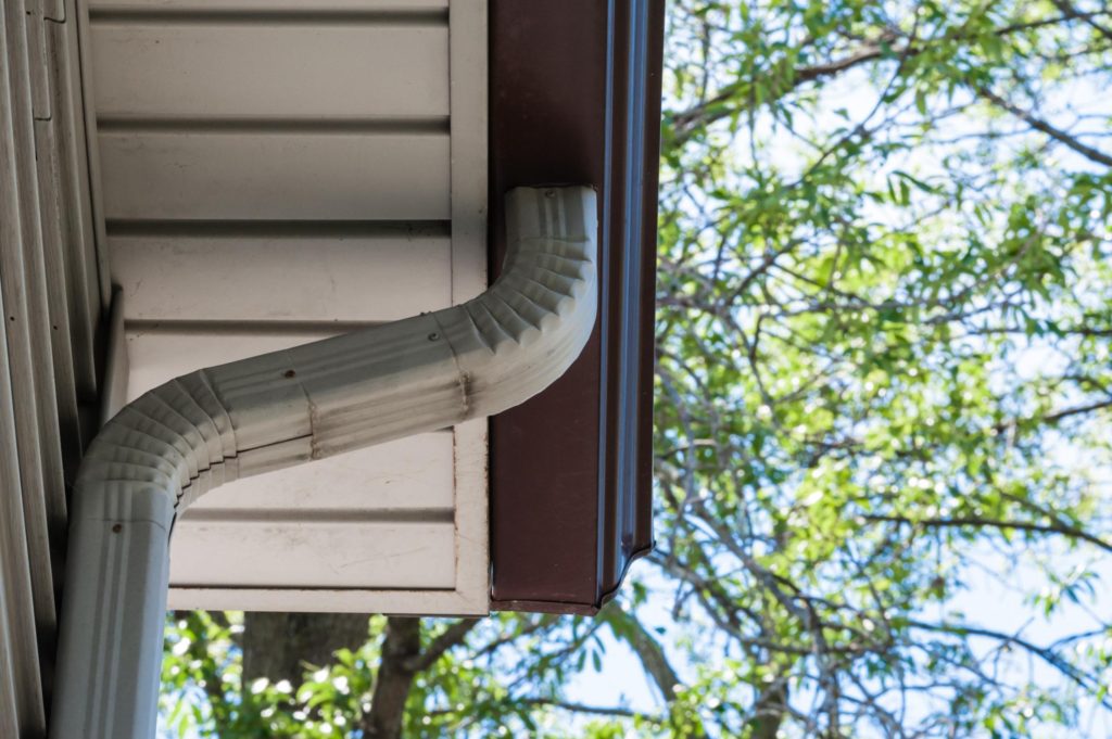 a soffit and roof downspout gutter